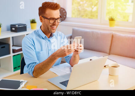 Handsome man paying bills with his phone Stock Photo