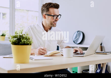 Freelancer working on laptop from home office Stock Photo