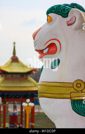 Traditional Buddhist lion on the background of a blurred pagoda in the distance. Russia. Republic of Kalmykia. Stock Photo