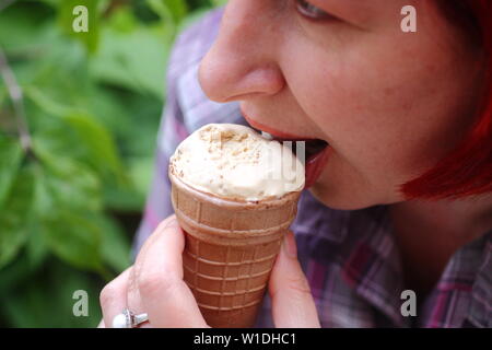 Girl enjoys ice cream in waffle glass Stock Photo