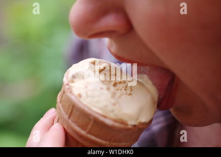 Girl eating ice cream in a waffle glass. Stock Photo