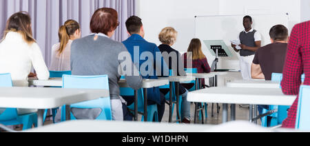 Multinational group of adult students working together with professor in auditorium Stock Photo
