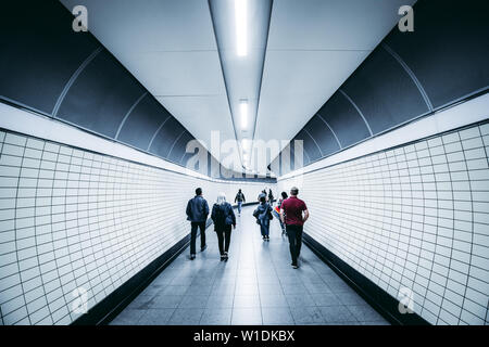 LONDON - JUNE 26, 2019: People walking in modern city tunnel on London Underground crossrail tube train station