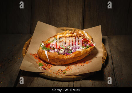 Sub roll filled with chicken and salad, on wooden background Stock Photo