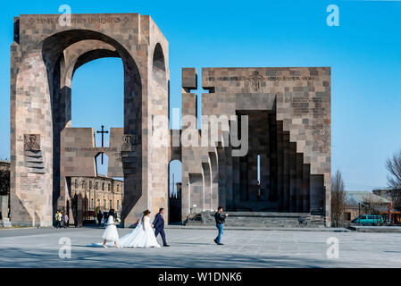 View of Open Air Altar, Main entrance to the monastery complex in Echmiadzin. Wedding couple is visiting monastery complex.  Vagashpat, Stock Photo