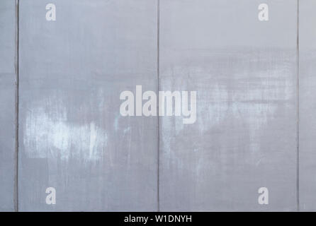 High resolution full frame background of a concrete wall painted in gray with lighter marks as a result of graffiti removal. Copy space. Stock Photo