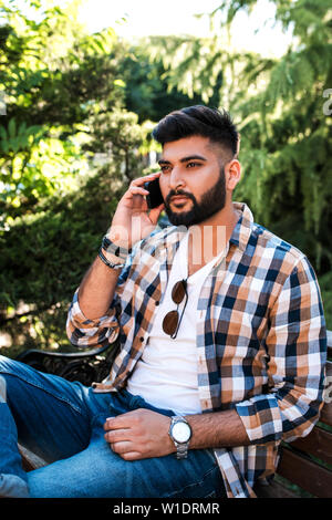 Handsome young indian man using mobile phone. Stock Photo