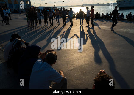 Istanbul, Turkey - June 10, 2019: Young people are  playing folklore at the seaside of The Istanbul, Kadikoy District,some people are watching them. Stock Photo