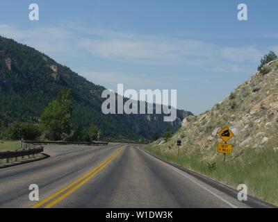 Scenic drive with roadside warning of a steep slope in the next four miles at Bighorn Mountains in Wyoming. Stock Photo