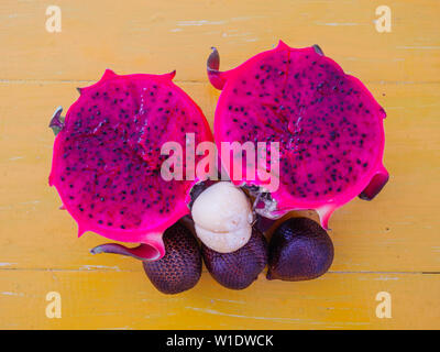 Dragon fruit and snake fruit on table. Delicious tropical fruit in South East Asia. Asian cuisine, tasty food, healthy lifestyle. Stock Photo