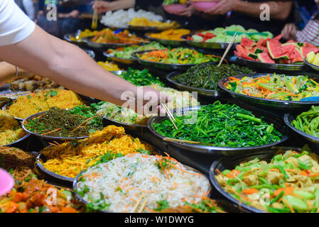 Street food in Luang Prabang, Laos. Delicious food stall selling colorful vegetable dishes to tourist. Asian cuisine, tasty food, healthy lifestyle. Stock Photo