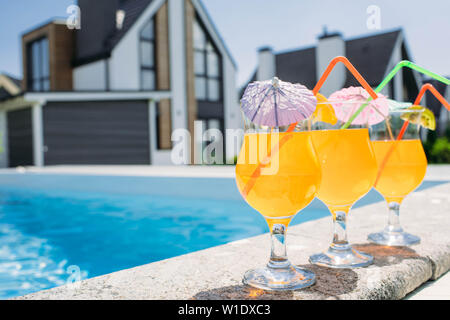glass of fresh orange juice by the poolside. Summer cocktail Stock Photo