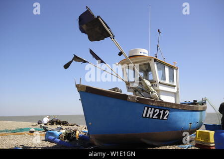 blue painted small fishing boat on dry land with a white cabin and flags flying Stock Photo