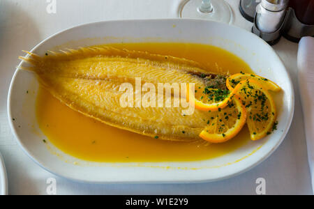 Delicious dover sole cooked in orange sauce served on white plate Stock Photo