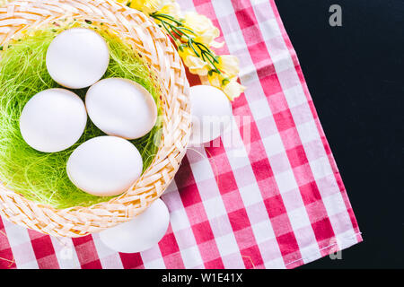 Eggs on tablecloth over black background Stock Photo