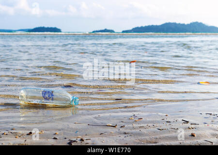 Waste water bottles that float on the beach side, environmental pollution problems from human beings. Stock Photo