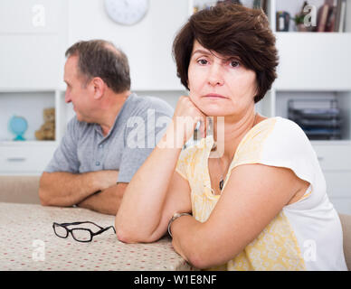 Portrait of worried mature woman having problems with her husband at home Stock Photo