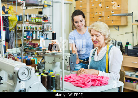 Portrait of two professional skilled female tailors working in the sewing workshop Stock Photo