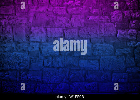 Neon colored limestone brick wall background. Horizontal toned and vignetted backdrop Stock Photo