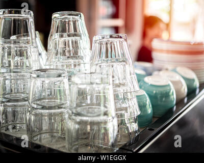 Pile of empty clean transparent glasses on shelf in cafe. Stock Photo