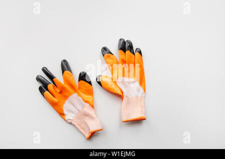 Orange work gloves on white background. housework concept. Stock Photo
