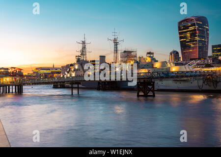Skyline of the City of London at sunset with HMS Belfast in the foreground, London, England, United Kingdom, Europe
