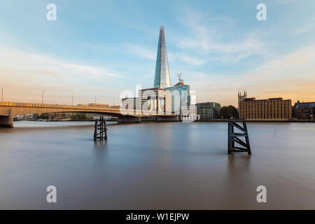 Long exposure of the River Thames with London Bridge and The Shard in the background by sunset, London, England, United Kingdom, Europe Stock Photo