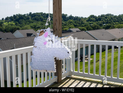 White unicorn shaped pinata after being beaten at childs party Stock Photo