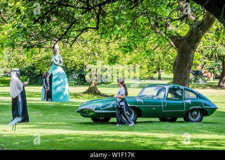 Regents Park, London, UK. 2nd July 2019. A family enjoy a work - Vik Muniz, Mnemonic Vehicle No.2 (2015), Presented by Ben Brown Fine Arts with in the background, Leiko Ikemura, Usagi Kannon II (2013-2018), Presented by Kewenig - Frieze Sculpture, one of the largest outdoor exhibitions in London, including work by 25 international artists from across five continents in Regent’s Park from 4th July - 7th October 2019. Credit: Guy Bell/Alamy Live News Stock Photo