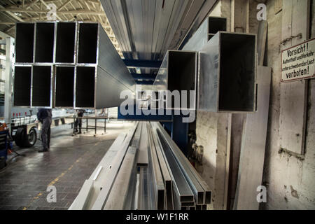 different sizes of rods piled up in old factory Stock Photo