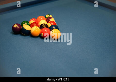 Set of billiard balls arranged in triangle on blue billiard pool table Stock Photo