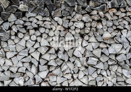 Background of splitted, dried and stacked firewood. Bunch of wood. Black and white photo. Stock Photo