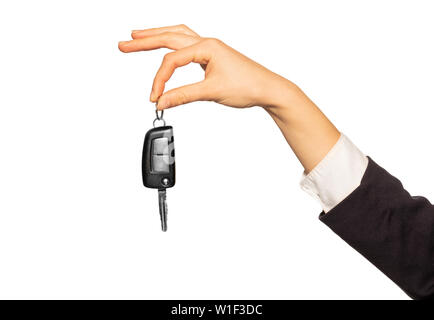 Woman's hand holding car key with index and thumb fingers, isolated on white background Stock Photo