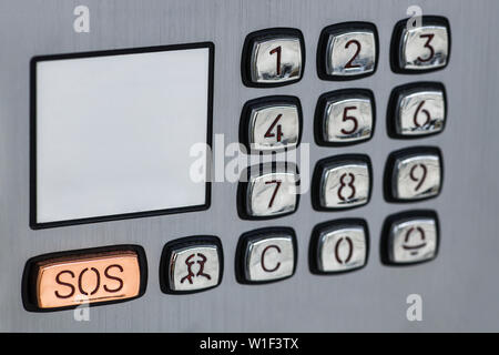 Intercom control panel of gray metal color with buttons -numbers and SOS button Stock Photo