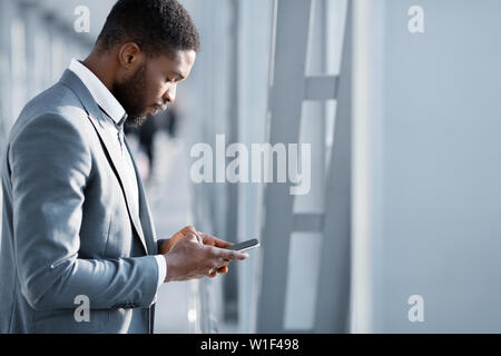 Man Texting on Phone, Waiting for Departure at Airport Stock Photo