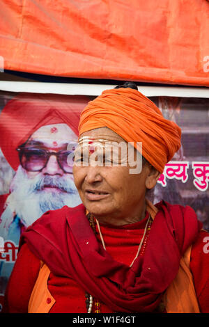 Portrait of a Sadhvi in orange red saree during Allahabad Kumbh Mela, For editorial use only, World’s largest religious gathering, Uttar Pradesh, Indi Stock Photo