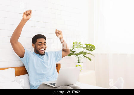 African american man extremely happy working with laptop Stock Photo