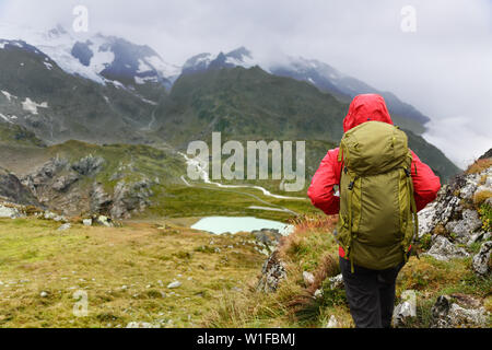 Hiking - hiker woman on trek with backpack living healthy active lifestyle. Hiker girl walking on hike in mountain nature landscape in Steingletscher, Urner Alps, Berne, Swiss alps, Switzerland. Stock Photo