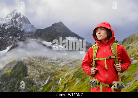 Alps Hiking - Asian hiker woman in Switzerland on trek in mountains with backpack living a healthy active lifestyle. Hiker girl on nature landscape hike in Urner Alps, Berne, Swiss alps, Switzerland. Stock Photo
