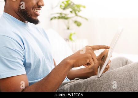 Relaxed casual man using tablet in bed Stock Photo