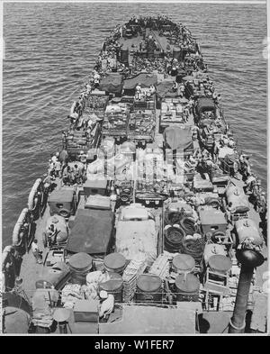 Invasion of Cape Gloucester, New Britain, 24 December 1943. Crammed with men and material for the invasion, this Coast Guard-manned LST nears the Japanese held shore. Troops shown in the picture are Marines.; General notes:  Use War and Conflict Number 855 when ordering a reproduction or requesting information about this image. Stock Photo