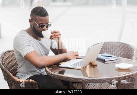 African american man reading news on laptop Stock Photo