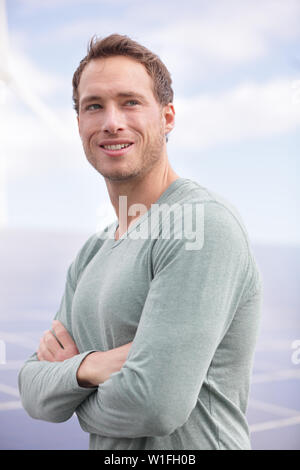 Portrait of young man entrepreneur solar panels outdoors. Casual young business man standing proud outside. Stock Photo