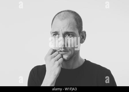 Close up portrait of young man with confused face thinking with a pensive expression looking Puzzled and doubtful. Isolated on white background, in Pe Stock Photo