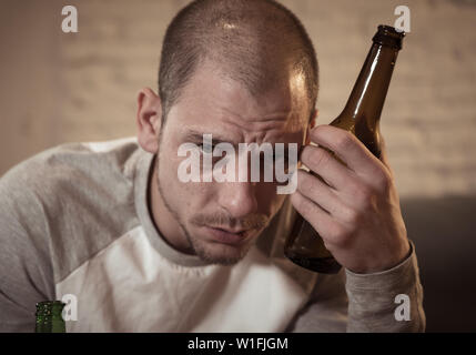 Young sad drunk men drinking beer and alcohol feeling wasted, lonely and desperate in pain and emotional stress. People and Alcohol abuse, addiction a Stock Photo
