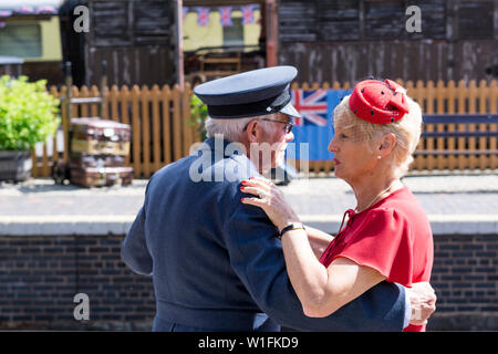 Kidderminster, UK. 29th June, 2019. Severn Valley Railways 'Step back to the 1940's' gets off to a fabulous start this weekend with costumed re-enactors playing their part in providing an authentic recreation of wartime Britain. A smartly-dressed couple in 1940's fashion are dancing together on the platform of a vintage railway station in the morning sunshine. Credit: Lee Hudson Stock Photo