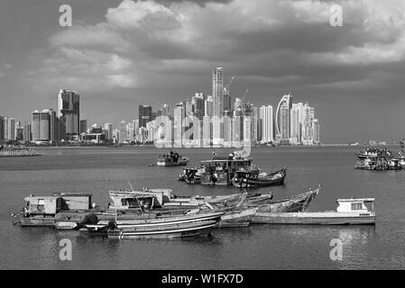 old wooden fishing boats in front of the skyline of panama city panama in black and white Stock Photo