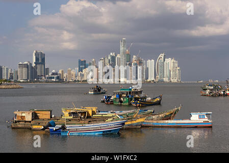 old wooden fishing boats in front of the skyline of panama city panama Stock Photo