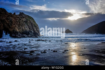 Sunset with surf and rocks at California beach.  Located in Big Sur off of California Highway 1. Stock Photo