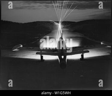 Leaving a fiery trail, .50 caliber bullets streak through the night as maintenance men of the 49th Fighter Bomber Wing in Korea, test fire a Republic F-84 Thunderjet. Wing guns will be checked and put in perfect firing order before the plane takes off in the morning on a bombing and strafing mission over enemy lines. Stock Photo